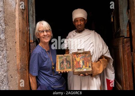 Etiopia, Amhara, Lalibela, Mount Abuna Yosef, all'interno, Asheton Maryam Monastero, mostrando antica icona dipinta a senior turista femminile Foto Stock