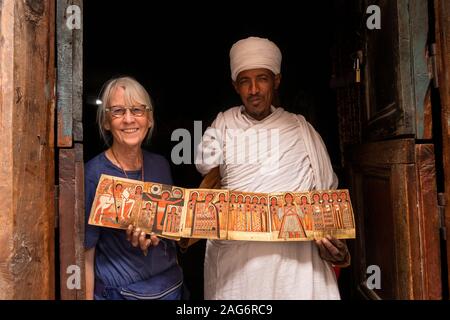 Etiopia, Amhara, Lalibela, Mount Abuna Yosef, all'interno, Asheton Maryam Monastero, mostrando antica icona dipinta a senior turista femminile Foto Stock