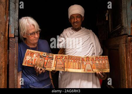 Etiopia, Amhara, Lalibela, Mount Abuna Yosef, all'interno, Asheton Maryam Monastero, mostrando antica icona dipinta a senior turista femminile Foto Stock