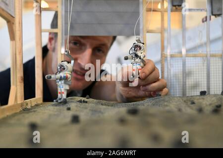 Il 10 dicembre 2019, Renania settentrionale-Vestfalia, Colonia: astronauta Matthias Maurer osserva gli astronauti in un modello del progetto Luna all'astronauta europeo Centro (EAC) presso la sede dell'ESA astronaut figure. Foto: Felix Hörhager/dpa Foto Stock