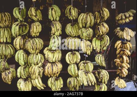 Colpo di primo piano di banane appese da una corda nel mercato Foto Stock