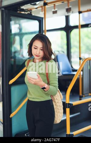Donna asiatica traveler andando fuori il bus terminal Foto Stock