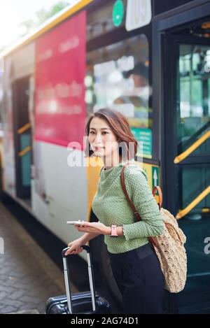 Giovani vietnamiti traveler andando fuori il bus terminal Foto Stock