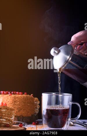 Il tè profumato con vapore in una tazza con un delizioso dessert. Foto di cibo Foto Stock