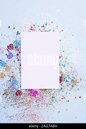 Carta bianca su sfondo azzurro con multi-colore luccica. Contenuto di vacanza Foto Stock