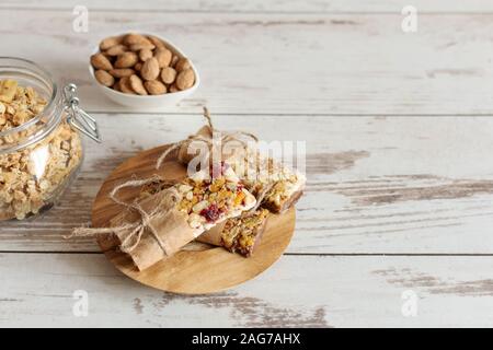 Cereali granola bar con i dadi, frutta e bacche sul tavolo di legno dello sfondo. Una sana dolce dessert caserecci snack. Foto Stock