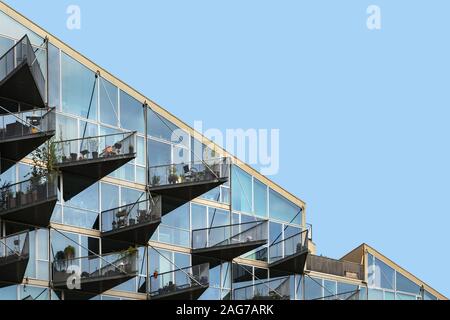 Foto ad angolo basso di un edificio moderno con balconi pieni di tipi differenti di piante Foto Stock