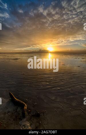 Immagine verticale di un bellissimo tramonto sulla spiaggia creazione il paesaggio perfetto per passeggiate serali Foto Stock