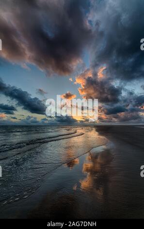 Immagine verticale di un bellissimo tramonto che si riflette nell'oceano creare lo scenario perfetto Foto Stock