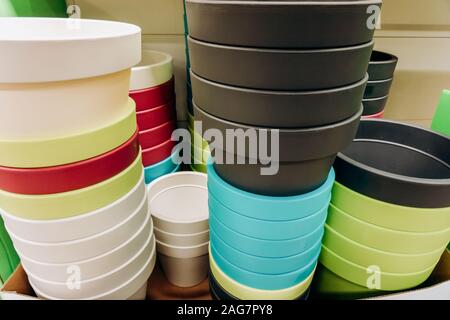 Plastica multicolore fioriere sul banco del negozio Foto Stock