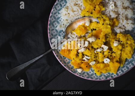 Un piatto delizioso con riso e. pollo coperto in salsa gialla Foto Stock