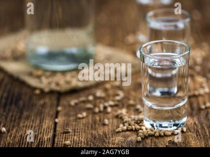 Tavolo in legno con liquore di grano (dettagliate di close-up shot; messa a fuoco selettiva) Foto Stock