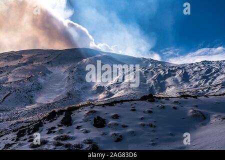 Die Sonne scheint durch die Wolken über dem schneebedeckten Vulkan Ätna, Sizilien, Italien, Europa | il sole che splende attraverso le nuvole sulla neve Foto Stock