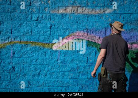 Ebbw Vale, Regno Unito - 13 Settembre 2019: Graffiti artist pittura parete edilizia arte con vernici spray per il gufo santuario per la città di Ebbw Vale, Wale Foto Stock