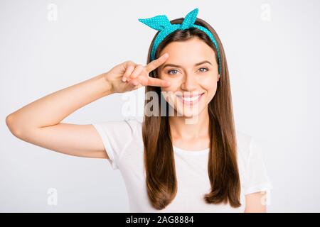 Ritratto di Allegro ragazza positivo avere divertimento per il tempo libero fanno v-segni di usura in stile casual vestiti isolato su bianco colore di sfondo Foto Stock