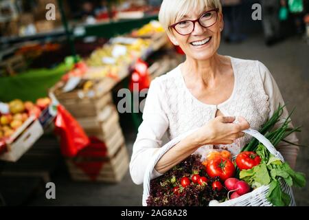 Solo i migliori frutti e verdure. Bella donna matura l'acquisto di alimenti freschi sul mercato Foto Stock