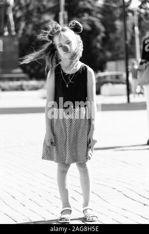 Ragazza sulla strada con un clown naso Foto Stock