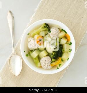 Ciotola di zuppa, una tazza di brodo e verdure, polpette di carne di tacchino e di pollo, vista dall'alto Foto Stock