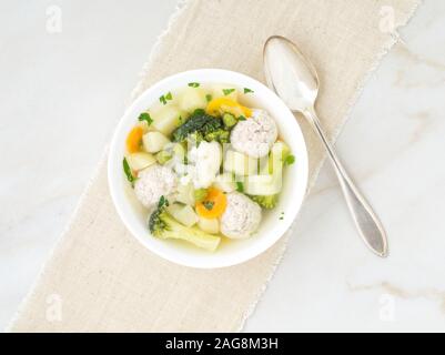 Ciotola di zuppa, una tazza di brodo e verdure, polpette di carne di tacchino e di pollo, vista dall'alto Foto Stock