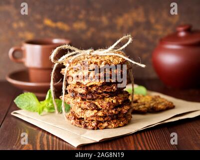 In casa i fiocchi d'avena i biscotti con banana, avena, dadi, le uova e la farina libera su un marrone scuro tavolo in legno, vista laterale. Foto Stock