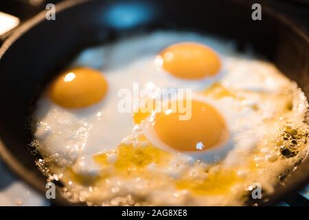 Frittata di uova è essere preparati in una padella close up - Tre uova giallo in Europa Orientale Lettonia Riga Foto Stock