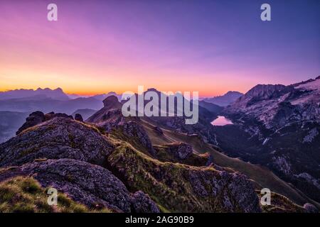 Vista delle dolomiti montagna paesaggio intorno al Lago Fedaia, Lago di Fedaia al Sunrise, il Setsas montagne in distanza Foto Stock