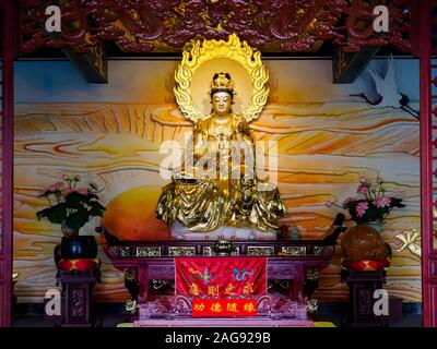 Statua dorata della Dea della Misericordia / Kwan Yin / Kuan Yin in un tempio taoista di Hainan in Cina Foto Stock