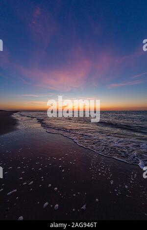 Immagine verticale dell'oceano calmo durante il tramonto a Vrouwenpolder, Zeeland, Paesi Bassi Foto Stock