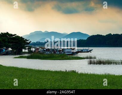 Barche da fiume attraccano sul fiume profumo a Hue, Vietnam Foto Stock