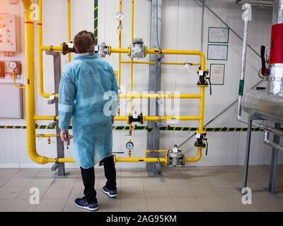 Ingegnere esamina le attrezzature nella sala caldaie Foto Stock