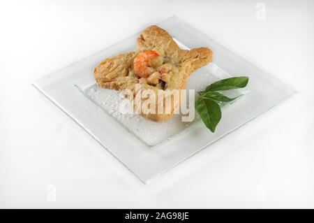 Colpo isolato di un piatto bianco con pasta sfoglia con gamberi - perfetto per l'uso del blog o del menu del cibo Foto Stock