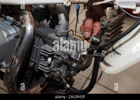 Master smantella la motocicletta di lavorare sulla parte elettrica della motocicletta Motocicletta di riparazione e di manutenzione. La diagnosi e la riparazione Foto Stock