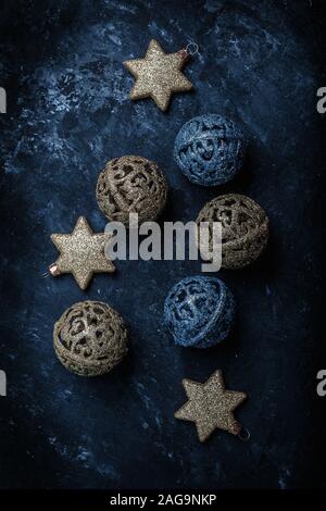 Anno nuovo Natale oro e blu le sfere e le stelle su uno sfondo scuro con paillettes sparse Foto Stock