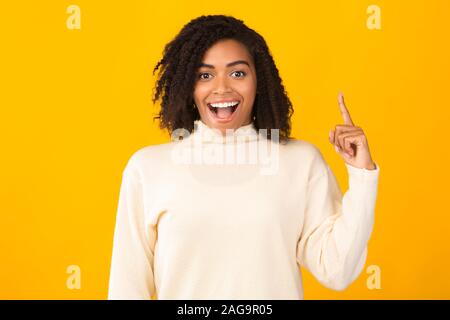 Eccitato nero ragazza avente grande idea rivolta verso l'alto Foto Stock