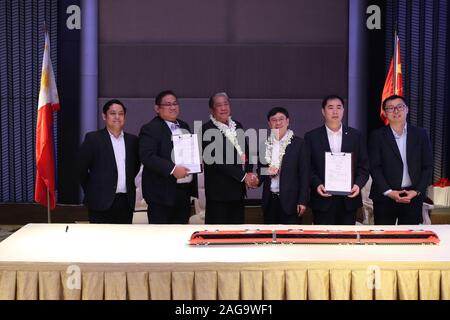 (191218) -- MANILA, Dic 18, 2019 (Xinhua) -- Philippine Segretario del Dipartimento dei trasporti Arthur Tugade (3 L) e fu Chengjun (terza R), general manager della Cina il materiale rotabile ferroviario Corporation (CRRC) Locomotiva Zhuzhou Co., Ltd., si stringono la mano durante la firma del contratto cerimonia tenutasi a Manila nelle Filippine, Dic 18, 2019. La Cina e le Filippine hanno firmato un accordo sugli appalti di treni su Mercoledì, come le Filippine di importazione cinese-treni realizzato per la prima volta. Secondo il contratto inchiostrato attraverso la Cina del materiale rotabile maker CRRC Locomotiva Zhuzhou Co., Ltd. e Phi Foto Stock