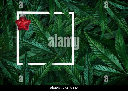 Creative sullo sfondo di Natale della loro cannabis foglie di marijuana e telaio con decorazione di Natale. Foto Stock