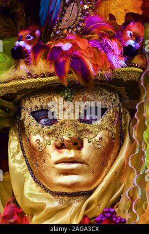 Scatto verticale di una persona che indossa una maschera dorata a. un carnevale Foto Stock