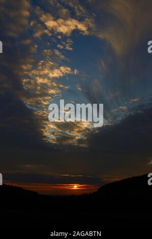 Cielo di tramonto con il foro del punzone nuvole Foto Stock