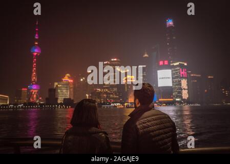 Splendida vista di una coppia che si erge sul molo Alla città di Shanghai catturata di notte Foto Stock