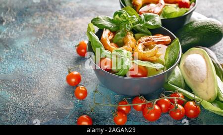 Banner di cibo. Gustosa insalata con gamberi fritti, avocado, radicchio e basilico. Gustosi e salutari frutti di mare. Foto Stock