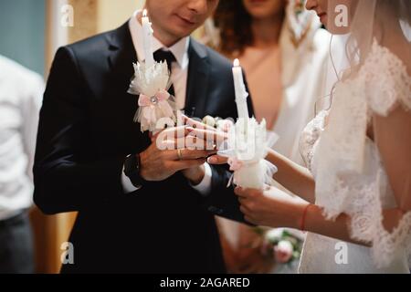 La sposa la mano indossa un impegno Anello oro su govern dito. Giorno di nozze. Le mani con anelli di nozze. Close up. Foto Stock