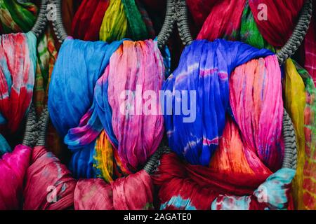 Pila di bright multi-colore di pezzi di tessuto in un bazar Foto Stock