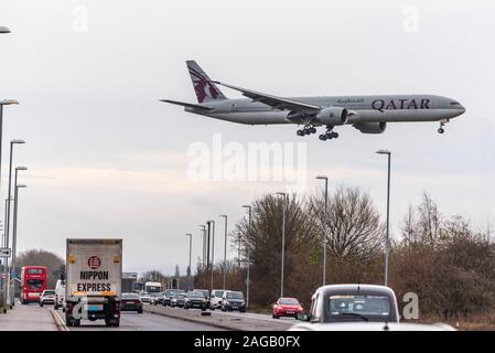 Qatar Airways Boeing 777-3DZ/ER attraversamento aereo di linea occupata Ringway Road presso l'aeroporto di Manchester. Foto Stock