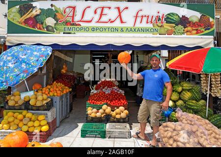 La frutta e la verdura venditore mostra una zucca al suo negozio, Zante città, Zante Island, Grecia Foto Stock