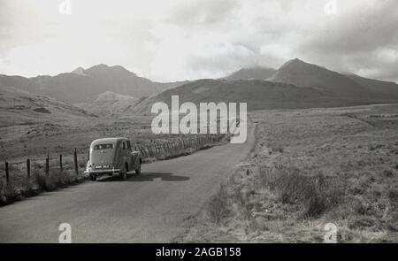 Anni '1950, storica automobile dell'epoca parcheggiata su una stretta strada di campagna a Long Mynd, Shropshire, Inghilterra, un altopiano di brughiera e brughiera, di cui nel 1965 grandi aree, quasi tutta la sua area montana, sono state portate dal National Trust e designate come un'area di straordinaria bellezza naturale (ANOB). Foto Stock