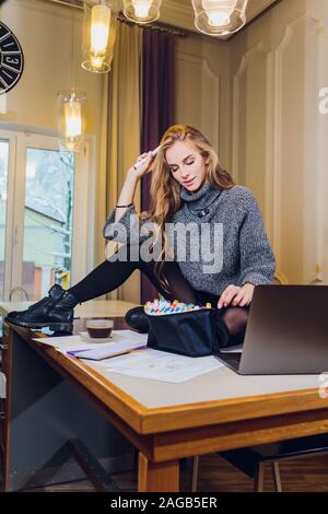 Professionale interior designer o architector lavora con tavolozza di colori e disegni in camera in un ufficio moderno. Giovane femmina modello futuro di pianificazione o piatta Foto Stock