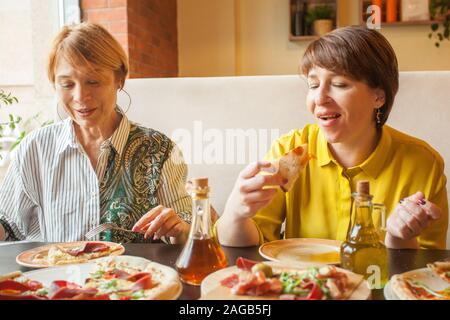 Due felici donne mature a mangiare e a chiacchierare nel ristorante italiano Foto Stock