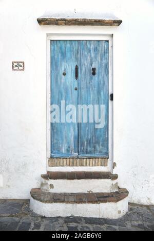Blue vecchia porta di legno con i segni dell'età su una casa bianca Foto Stock