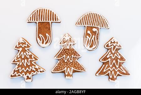 Gingerbreads ornati in struttura o conformazione a fungo su sfondo bianco. Set di cotto tradizionale del Natale e del Nuovo Anno decorazioni. Carino cookie aromatico. Foto Stock