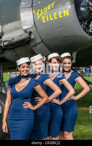 Periodo hostess costumi di stile al Goodwood 2014 utilizzando il tunnel accesso sotto il famoso circuito automobilistico. Le femmine in periodo vestire Foto Stock